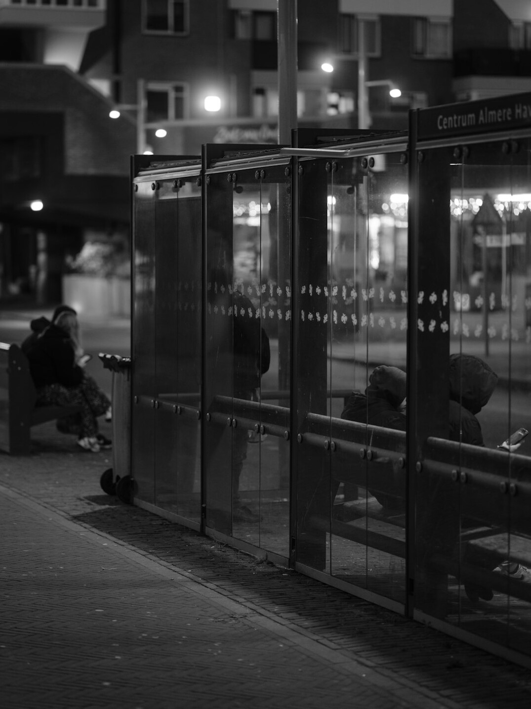 people waiting at bus stop in city