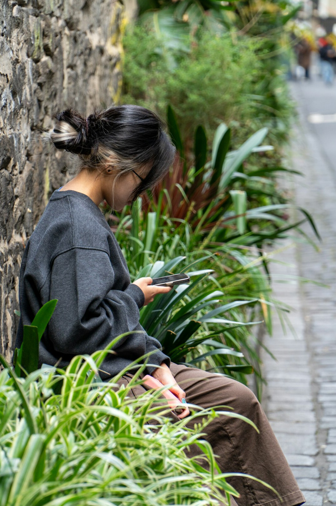 woman checking phone on street